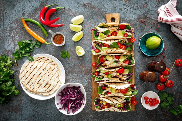 Izgara et, avokado, taze sebze salatası ve sos soslu tavuk tacoları.