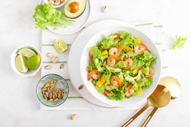 Avokado, mango, marul ve şam fıstıklı ızgara karides salatası. Limonlu. Sağlıklı yiyecekler. Ketogenik diyet. Üst görünüm.