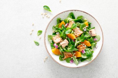 Çam fıstıklı, kırmızı soğanlı ve mısır salatalı portakal salatası.