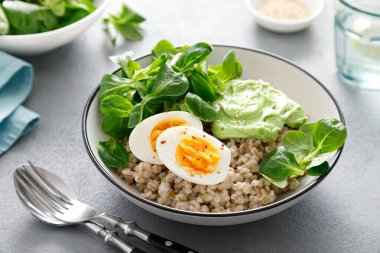 Yumuşak yumurta ve mısır salatalı inci arpa kasesi.