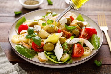 Peynirli, zeytinli, domatesli ve taze fesleğenli tavuk Caprese makarna salatası.