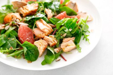 Greyfurtlu ızgara somon salatası, badem ve salata karışımı.