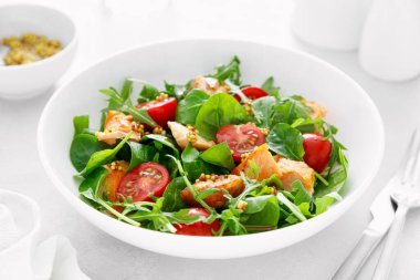 Izgara somon salatası, domates ve salata karışımı.