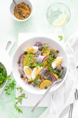 Ringa balığı ve haşlanmış patates salatası, yumurta, kapari ve kırmızı soğan. Üst görünüm