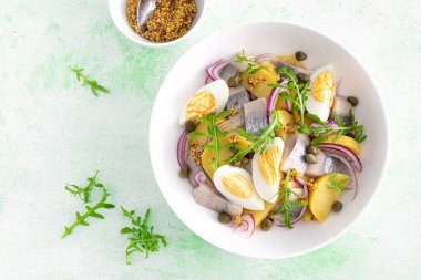 Ringa balığı ve haşlanmış patates salatası, yumurta, kapari ve kırmızı soğan. Üst görünüm