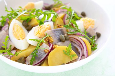 Ringa balığı ve haşlanmış patates salatası, yumurta, kapari ve kırmızı soğan.