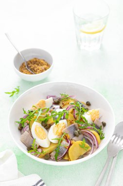 Ringa balığı ve haşlanmış patates salatası, yumurta, kapari ve kırmızı soğan.