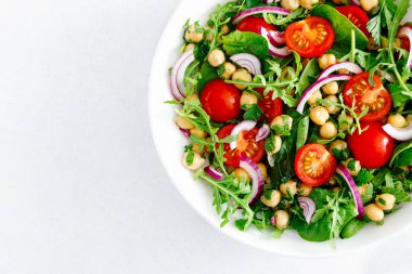 Domates, roka, maydanoz, ıspanak ve kırmızı soğanlı vejetaryen nohut salatası. Sağlıklı yiyecekler, diyet. Üst görünüm