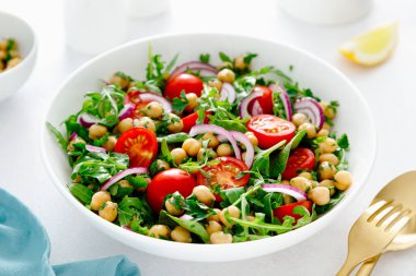 Domates, roka, maydanoz, ıspanak ve kırmızı soğanlı vejetaryen nohut salatası. Sağlıklı yemek, diyet