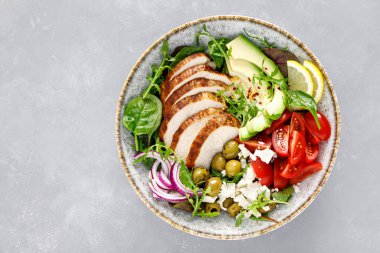 Izgara tavuk göğsü ve domatesli taze sebze salatası, beyaz peynir, zeytin ve avokado. Sağlıklı yiyecekler. Üst görünüm
