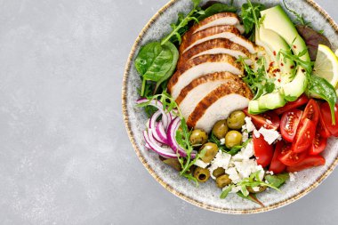 Izgara tavuk göğsü ve domatesli taze sebze salatası, beyaz peynir, zeytin ve avokado. Sağlıklı yiyecekler. Üst görünüm