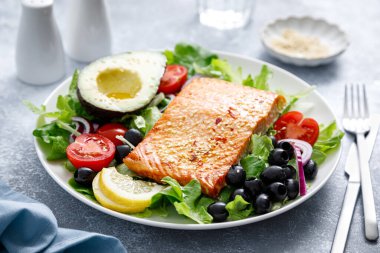 Izgara somon balığı fileto ve domatesli taze sebze salatası, kırmızı soğan, siyah zeytin ve avokado.
