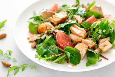 Greyfurtlu ızgara somon salatası, badem ve salata karışımı.