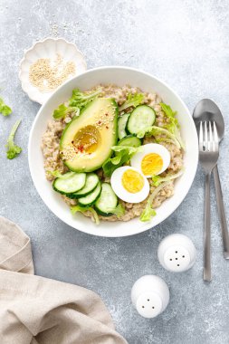 Haşlanmış yumurta, salatalık ve avokado ile yulaf lapası.
