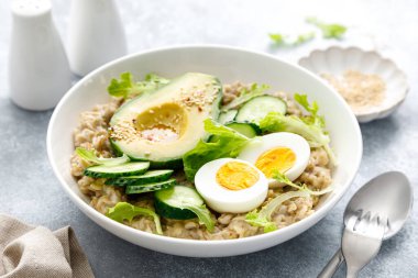 Haşlanmış yumurta, salatalık ve avokado ile yulaf lapası.