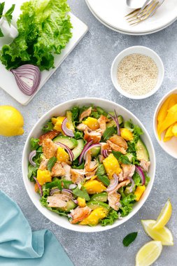 Izgara somon ve avokado ve taze yeşil marullu mango salatası.