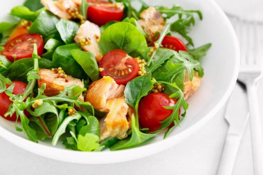 Izgara somon salatası, domates ve salata karışımı.