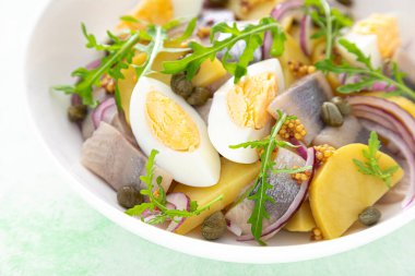 Ringa balığı ve haşlanmış patates salatası, yumurta, kapari ve kırmızı soğan.