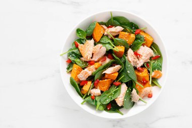 Spinach, salmon and sweetpotato festive thansgiving salad with pomegranate, top view