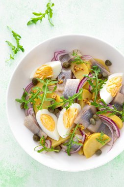 Ringa balığı ve haşlanmış patates salatası, yumurta, kapari ve kırmızı soğan. Üst görünüm