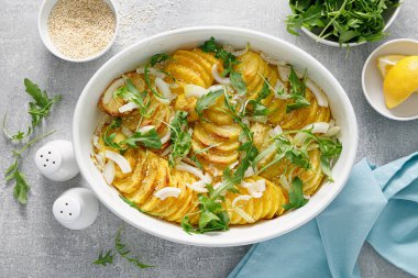 Soğanlı fırında patates ve taze roka.