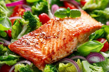 Somon balığı fileto ızgara ve kırmızı soğan ve brokoli ile taze domates salatası. Sağlıklı yiyecekler, diyet. Ketogenik öğle yemeği