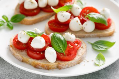 Küçük mozzarella peynirli, kiraz domatesli ve fesleğenli Caprese tostları