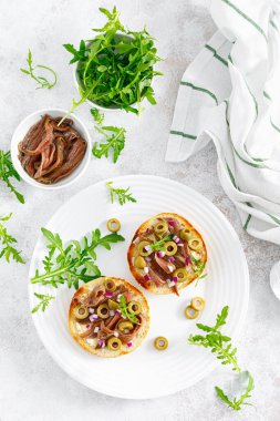 Zeytin ve roka ile ançüez tostu. Üst görünüm