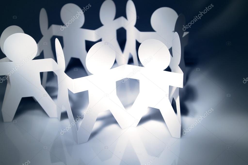 Team of paper doll holding hands in a circle