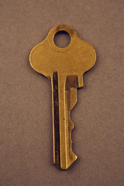 Key on brown background — Stock Photo, Image