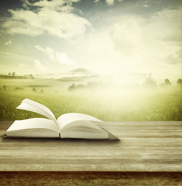 Open book on table in front of spring background