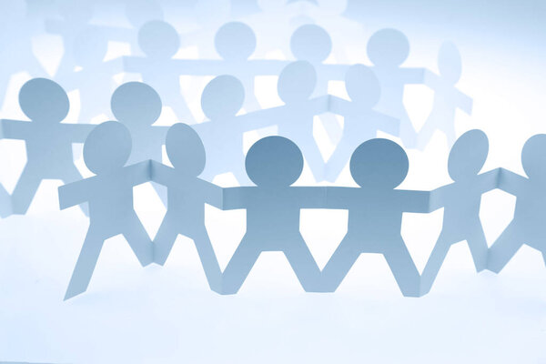 Команда людей из бумажной цепи объединилась, взявшись за руки