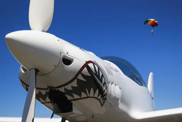 burun ve mavi gökyüzü ve paraşüt içinde beyaz bir uçak pervanesi