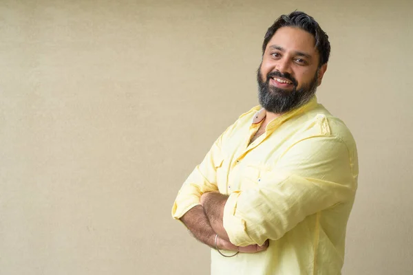 Portrait of handsome Indian man against plain background