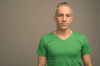 Studio yeşil gömlek gri arka plan gri saçlı yakışıklı Farsça adam vurdu