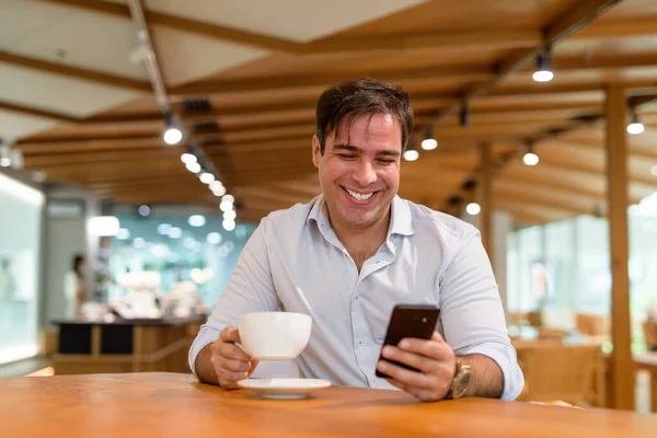 Портрет Красивого Персидского Мужчины Сидящего Кафе Используя Мобильный Телефон — стоковое фото