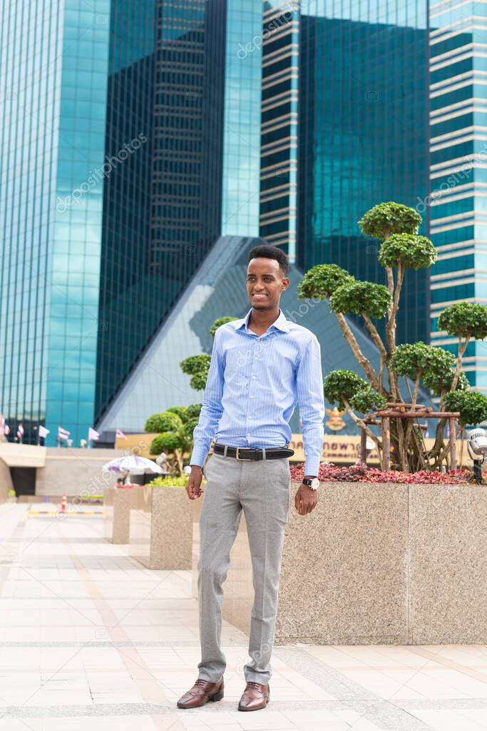 Handsome young black businessman outdoors in city