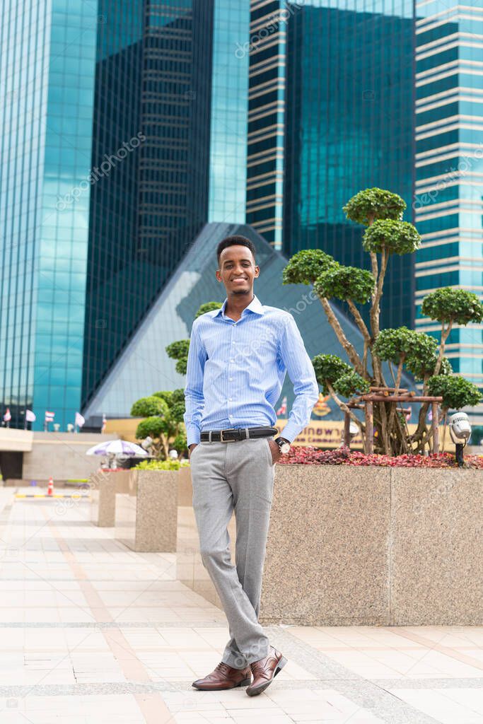 Handsome young black businessman outdoors in city