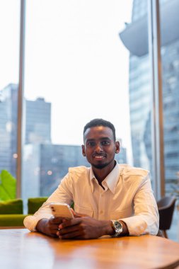 Portrait of young handsome stylish black man enjoying city life