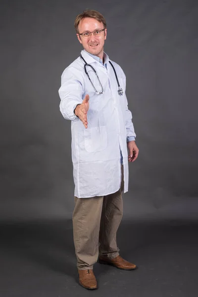 Uśmiechnięty Lekarz Stetoskopem Szyi Płaszczu Medycznym Oferujący Uścisk Dłoni Szarym — Zdjęcie stockowe