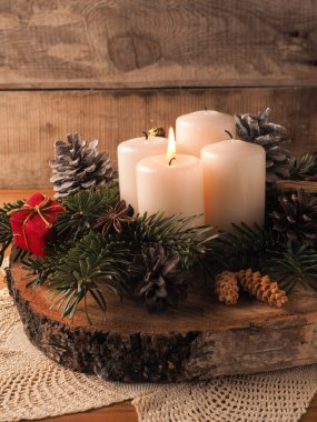 İlk olarak, bir mum Noel süslemesi ile birlikte ahşap bir masada yanıyor.