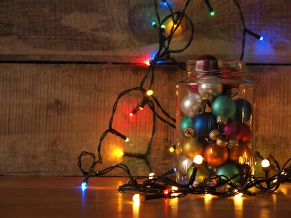 Ένα Βάζο Καραμέλα Γεμάτη Μπάλες Χριστούγεννα Και Διακοσμημένα Πολύχρωμα Φώτα — Φωτογραφία Αρχείου