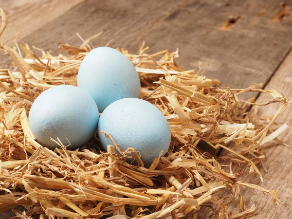 With natural dyes self-dyed organic eggs in a straw nest, holiday or healthy food concept