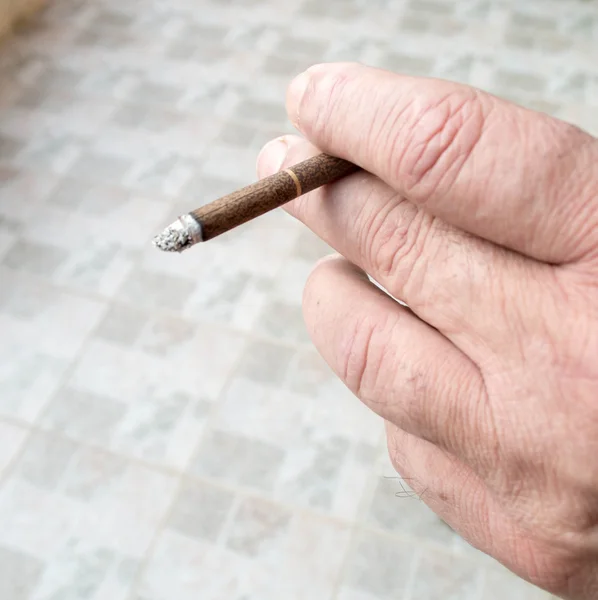 Man hand met een zwarte sigaret — Stockfoto