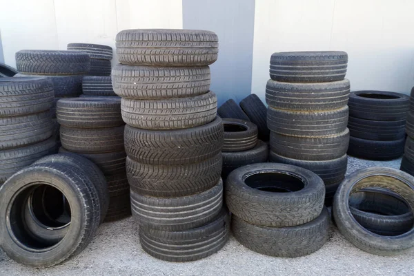 旧汽车轮胎堆在轮胎修理厂的院子里 — 图库照片