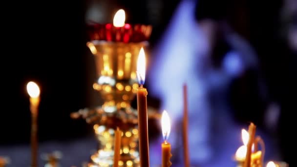 Многие свечи зажжены рядом с христианским крестом . — стоковое видео