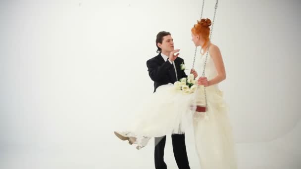 Невеста катается на качелях — стоковое видео