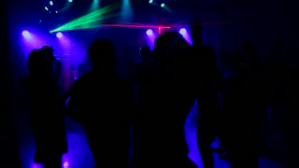 Una pareja divertida en la discoteca. bailando en una discoteca donde hay un hermoso espectáculo de láser . — Vídeo de stock
