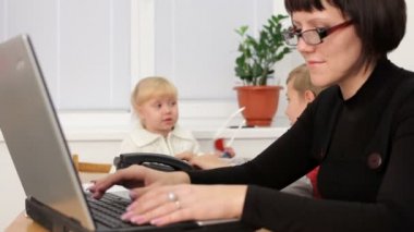 bekar bir anne. annelerinin sert dizüstü bilgisayarda çalışır iken, iki küçük çocuk oynadı. hareket zoom