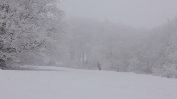 Extrem snowboard. snowboardåkare kommer ner för backen från dimman. — Stockvideo